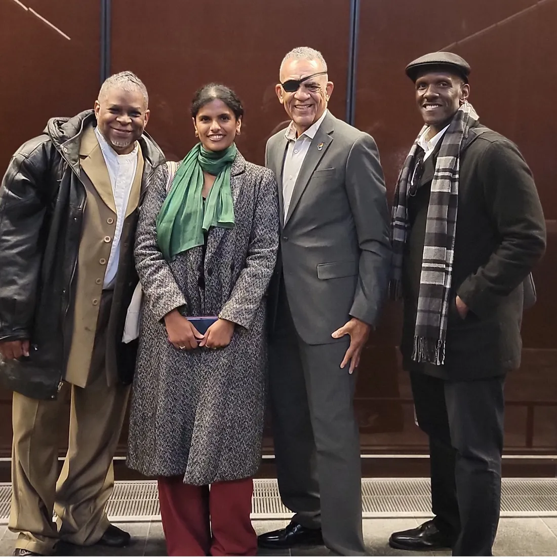 Four people in winter coats pose together in a hallway during a visit to Washington, D.C.