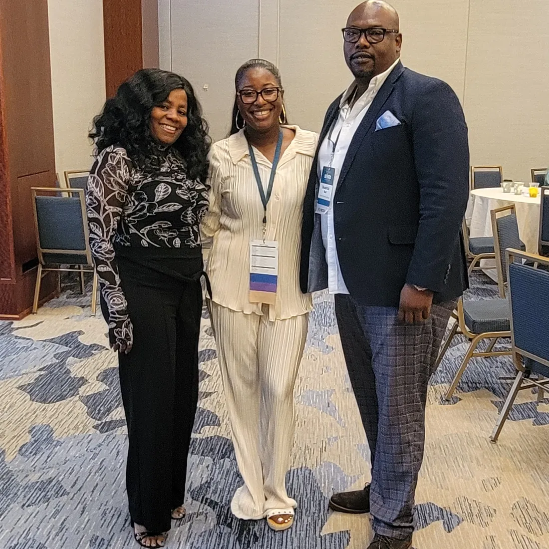 TBAH staff stand with a visitor in a conference room set for a meeting